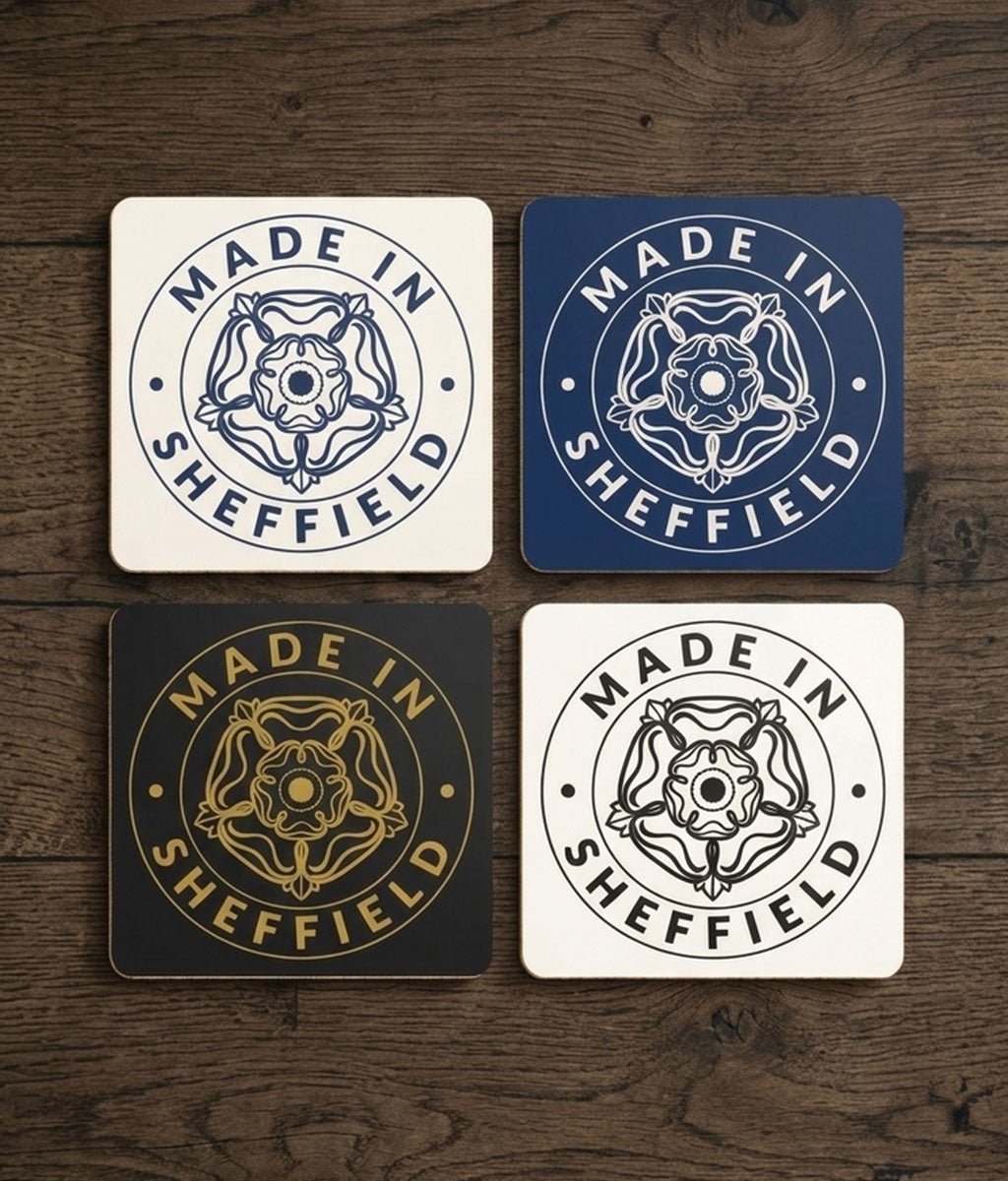 Four coasters with 'Made in Sheffield' design on a wooden surface