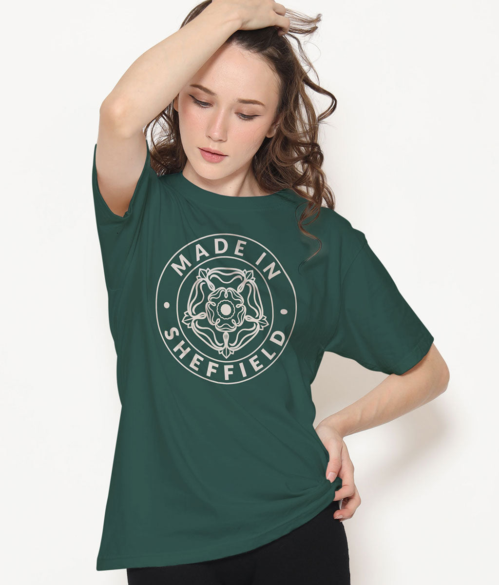 Person wearing a green t-shirt with 'Made in Sheffield' design on a white background