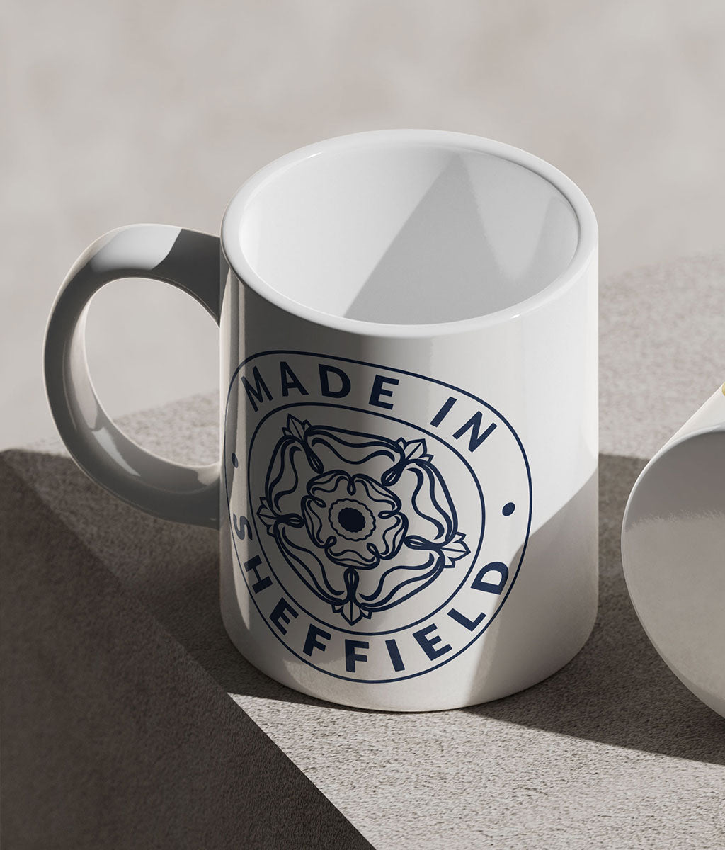 White mug with 'Made in Sheffield' design on a gray background