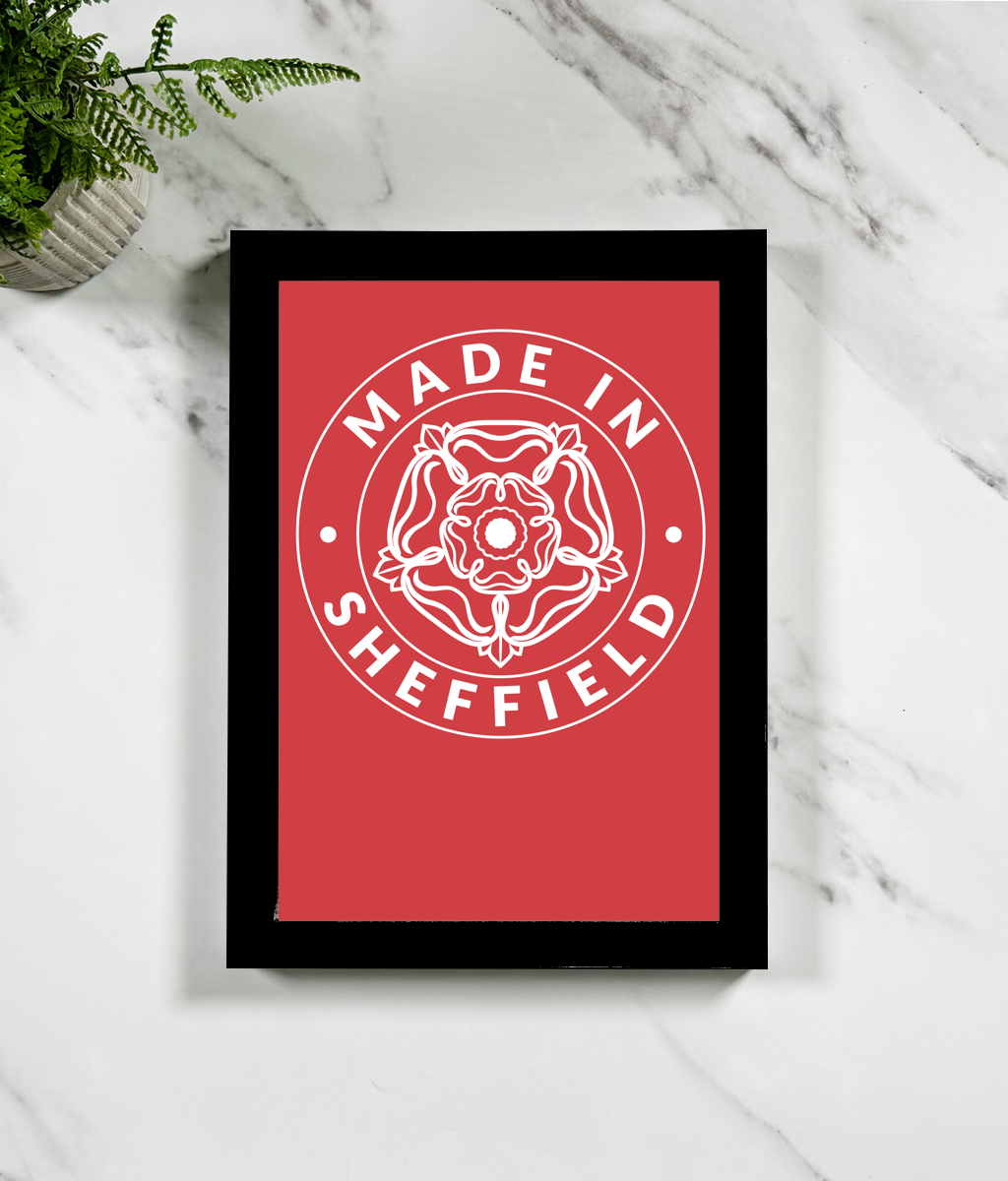 Framed print with 'Made in Sheffield' design on a red background, placed on a marble surface.