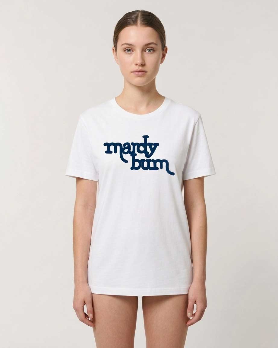 A woman modeling a white short-sleeve crewneck t-shirt with the words 'mardy bum' printed in dark blue script across the chest, set against a plain light gray background.