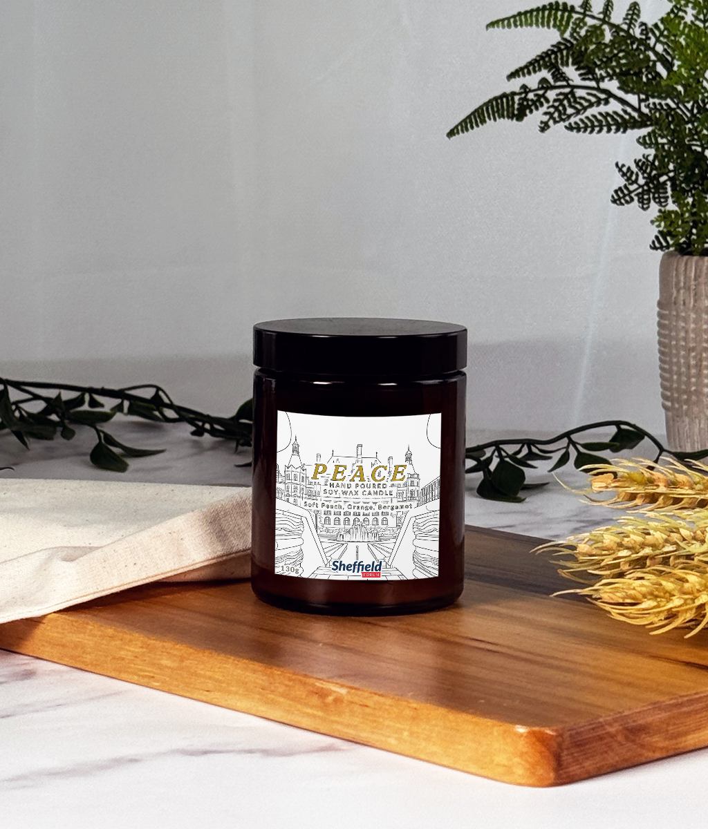 Candle with a 'Peace' label on a wooden surface with decorative elements